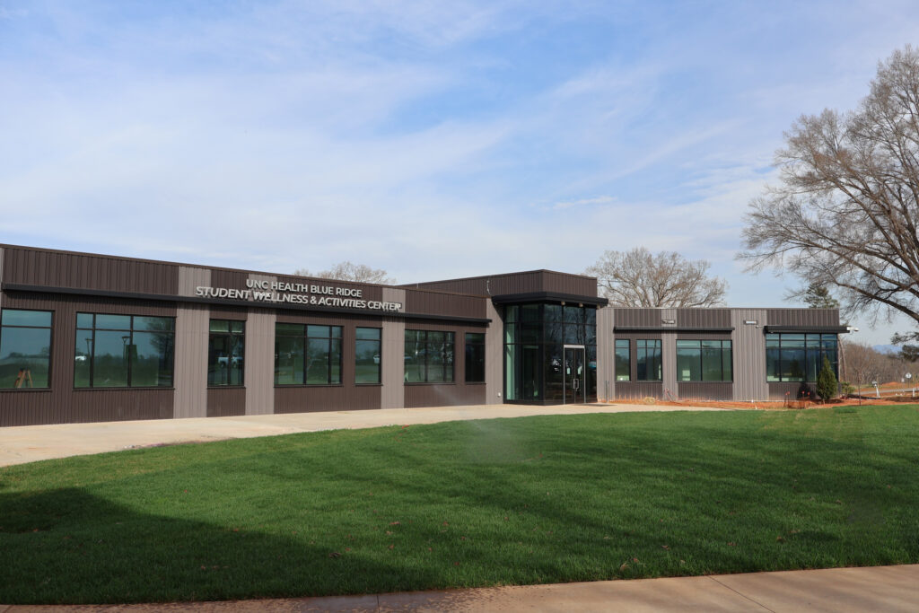 This exterior view of NCSSM-Morganton's UNC Health Blue Ridge Student Wellness and Activities Center shows the glass and steel building completed and ready for students.